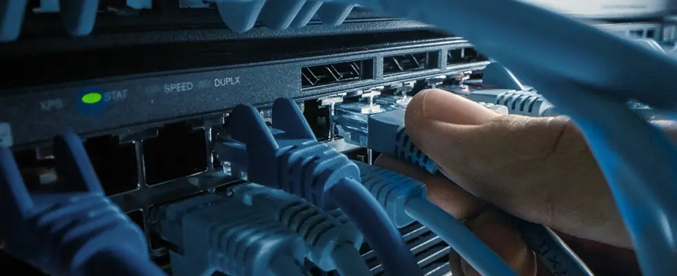 Network computer engineer connecting cables to a server