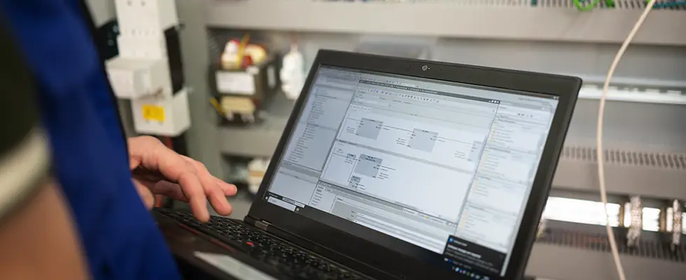 Engineer checking PLC data connections in a SCADA system